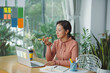 © Marc Tran/Stocksy - Thoughtful Asian woman holding mobile phone, sitting at desk