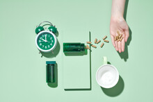 Pills, Bottles And A Glass Of Water On A Light Green Background.