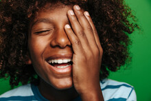 Cheerful Latin Boy Covering Face With Hand