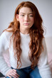 © Guille Faingold/Stocksy - Redhead girl looking at camera on bed.