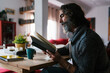 © Ezequiel Giménez/Stocksy - Man reading book at table