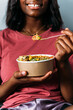 © David Prado/Stocksy - Faceless black woman eating poke bowl