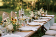 © Serena Burroughs/Stocksy - close up of wedding reception table setting with flower arrangements