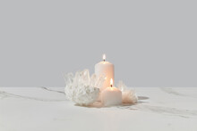 Burning Candles And Quartz Crystals On Marble Background