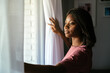 © David Prado/Stocksy - Black woman looking out window