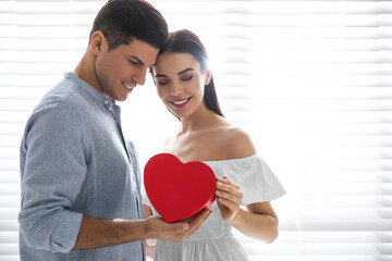 Poster - Lovely couple with gift box at home. Valentine's day celebration