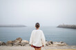 © Lupe Rodríguez/Stocksy - young woman looking at the sea in a nice portuguese port
