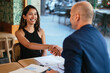 © BONNINSTUDIO/Stocksy - Happy candidate shaking hands with boss