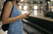 © Pedro Merino/Stocksy - Girl waiting for the train at the station using smartphone