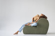 © Javier Pardina/Stocksy - Beautiful young woman lying on a sofa