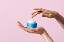 Woman Hand Holding Jar Moisturizer Cream Isolated On Pink Background.