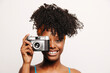 © VICTOR TORRES/Stocksy - Smiling black woman with vintage photo camera