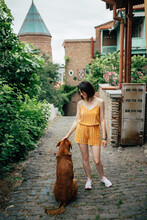 Attractive Girl Petting A Dog On An Old Eastern Pedestrian Street