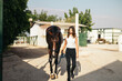 © Pedro Merino/Stocksy - Woman with horse in an equestrian center