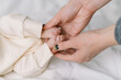 © Serena Burroughs/Stocksy - close up image of a mothers hands holding small newborn feet