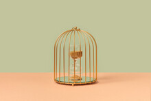Golden Birdcage With Hourglasses Inside.