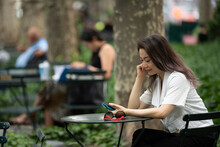 Woman Sitting At Table In Park