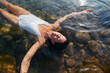 © Lucas Ottone/Stocksy - Woman floating in the river waters