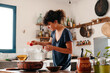 © Lucas Ottone/Stocksy - Woman cooking a traditional dish in the kitchen