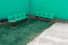 Green fences and green benches in the corner of the stadium.