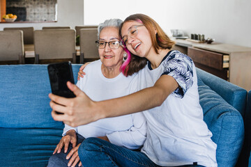 Hispanic family grandmother and granddaughter taking a selfie photo at home in Mexico Latin America