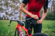© Daniel Gonzalez/Stocksy - Crop cyclist fastening bag on bike