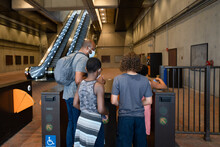 Father And Children Pass Through Metro Pay Point