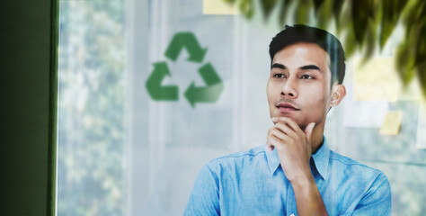 ESG Concepts. Environmental, Social and Corporate Governance. Young Asain Businessman Looking at Recycled Icon on transparent Board. Thought about Green Energy, Renewable and Sustainable Resources.