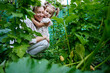 © AD Astra Team/Stocksy - Mom and daughter pick vegetables in the garden