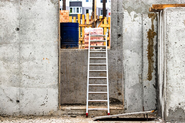 Metal aluminum ladder or ladder at a construction site in the basement of a concrete monolithic house.