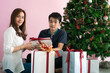© themorningglory - Man giving  christmas present to his girlfriend and decorate christmas tree celebrate winter new year