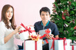 © themorningglory - Man giving  christmas present to his girlfriend and decorate christmas tree celebrate winter new year