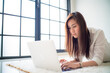 © themorningglory - Business asian woman lying on living room use laptop