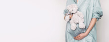 Woman Expecting Baby. Pregnant Girl Touching Belly And Teddy Bear Toy Resting, Awaiting The Child Birth. Natural Pregnancy At Home. Pregnancy, Maternity, Preparation, Baby Expectation Concept