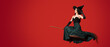 Young witch flying on broom against red background with space for text
