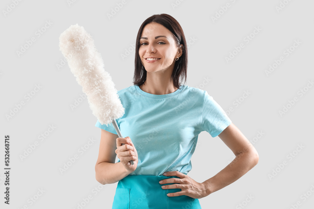 Beautiful woman with duster on light background