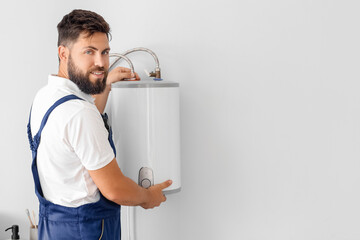 Poster - Male plumber installing boiler in bathroom