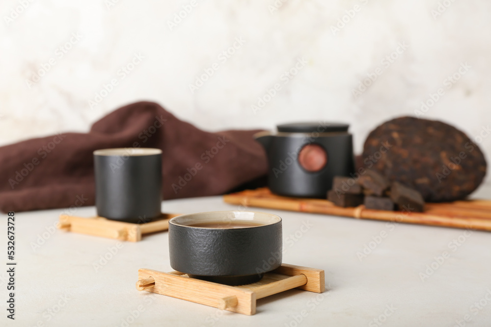 Stand with cup of puer tea on white background, closeup