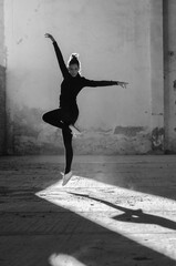 Wall Mural - Ballerina dancing in an abandoned building on a sunny day in black and white