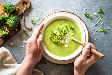 Green soup. Broccoli cream soup with cream and parmesan. Healthy vegan dish. Top view at white table.