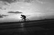 © Solid photos - Young sports man cycling with bicycle on the road in summer in black and white