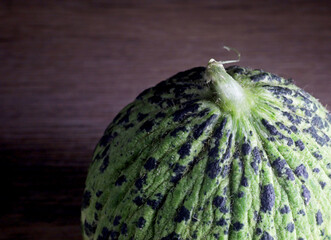 close-up organic green raw melon on a black background