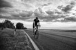 © Solid photos - Young sports man cycling with bicycle on the road in summer in black and white