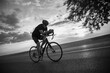 © Solid photos - Young sports man cycling with bicycle on the road in summer in black and white