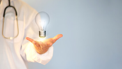 Poster - Concept of idea innovation and inspiration Man's hand holding an illuminated light bulb, concept creativity with glittering bulbs. Idea generation for long-term business development