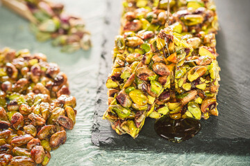 Pouring honey on traditional sugar coated pistachio sweets. Egyptian oriental dessert usually eaten during 