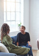 © AILA/peopleimages.com - two woman friends talking having conversation sitting on sofa at home
