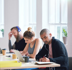 College students sitting at table in class working on project