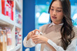 © whyframeshot - Attractive asian Beautiful female woman with shopping bags are choosing cosmetics and smiling while doing shopping store in the department  store shopping mall casual lifestyle