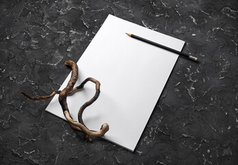 Wall Mural - Blank letterhead, pencil and dry branch on black plaster background. Blank branding template.